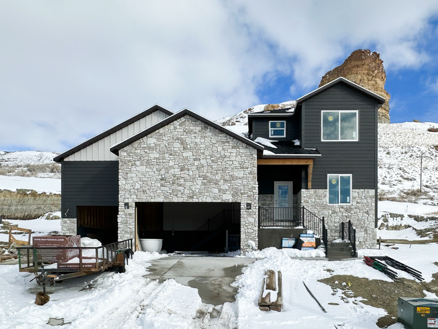 627 Memory Lane featuring tan and coffee siding, brown shingles, sleek black hardware and finishes, jasmine white quartz countertops, and white cabinetry.